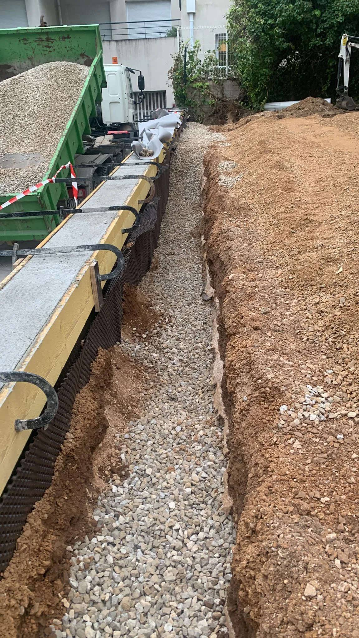 Réfection mur de soutenement dalles béton drainantes copropriété Montpellier 01 Pose des graviers de drainage derrière le mur de soutènement reconstruit par SOCCTP dans une copropriété de Montpellier