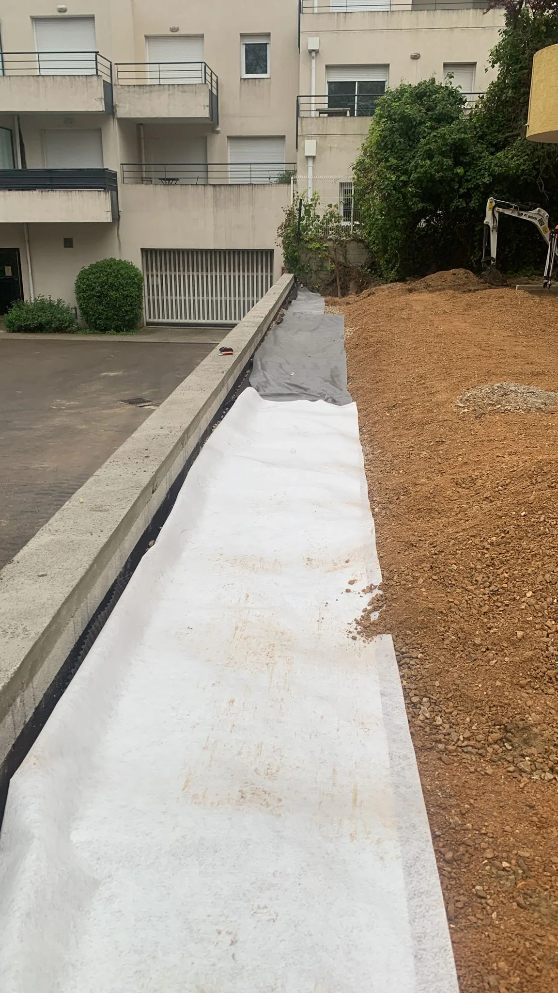 Réfection mur de soutenement dalles béton drainantes copropriété Montpellier 03 Pose du géotextile au-dessus du drain du nouveau mur de soutènement construit par SOCCTP dans cette copropriété de Montpellier